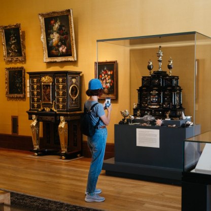 Visitor taking a photograph in the flowers gallery at the Fitzwilliam Museum